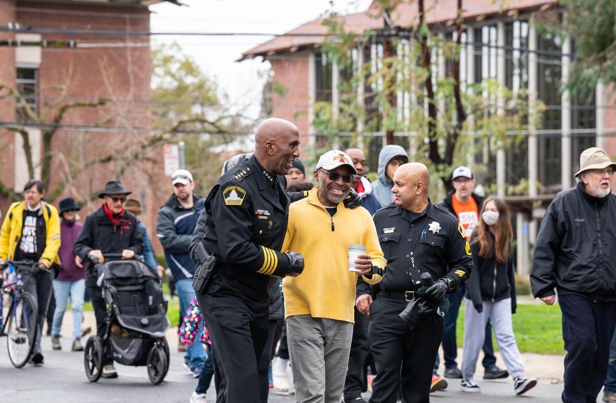 Recently sworn-in Sacramento County Sheriff Jim Cooper talks with other marchers during the MLK365 March for the Dream honoring Martin Luther King Jr. on Monday, Jan. 16, 2023, in Sacramento. The main march began and ended at Sacramento City College in a “love loop” that included Land Park Drive, Broadway and Freeport Boulevard.