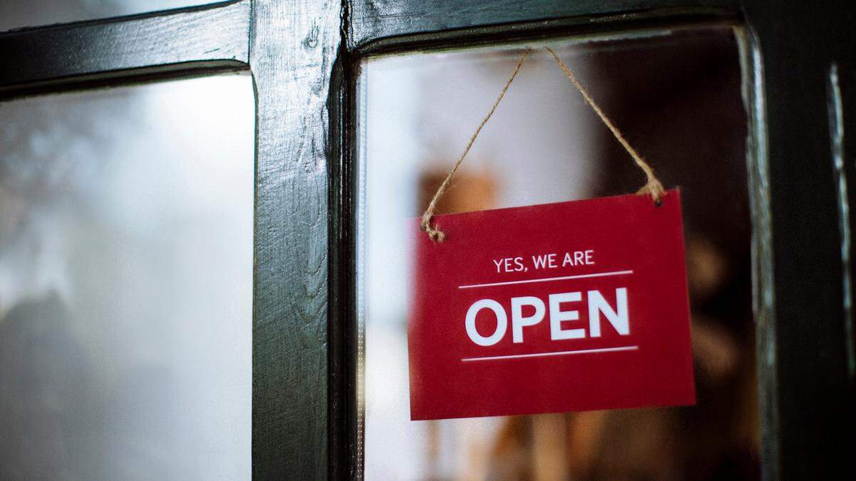 Open sign hanging behind an shop entrance door