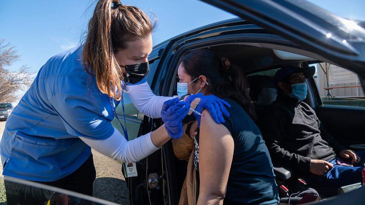 Registered nurse Darcy Olander gives the Pfizer COVID-19 vaccine to farmworker Irma Jimenez, 33, on Wednesday, Feb. 17, 2021 at a farm near Esparto as part of a Yolo County pilot program to vaccinate essential workers. About 7,000 farmworkers live in the county, which is known for its large tracts of agricultural land.