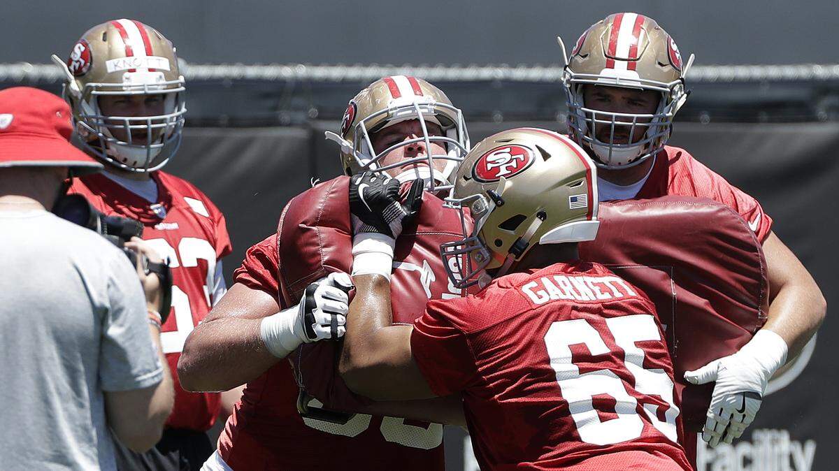 Rookie Mike McGlinchey, center, blocks fellow offensive lineman Joshua Garnett during the 49ers' mandatory minicamp June 13 in Santa Clara. The team reports to training camp Wednesday.