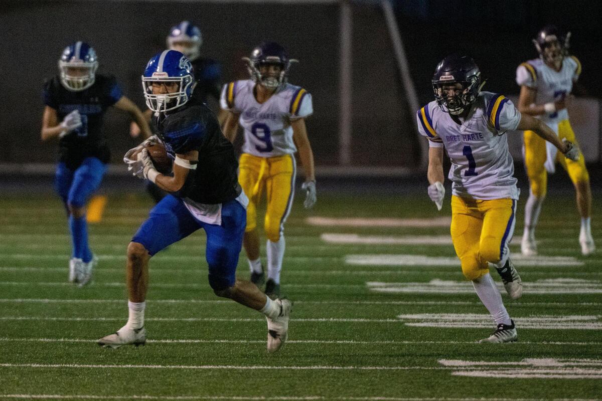 El Dorado’s Devon Finau runs after after a catch, chased by Bret Harte’s Ezra Radabaugh (1), during a game at El Dorado High School in Placerville on Monday, Sept. 12, 2022.