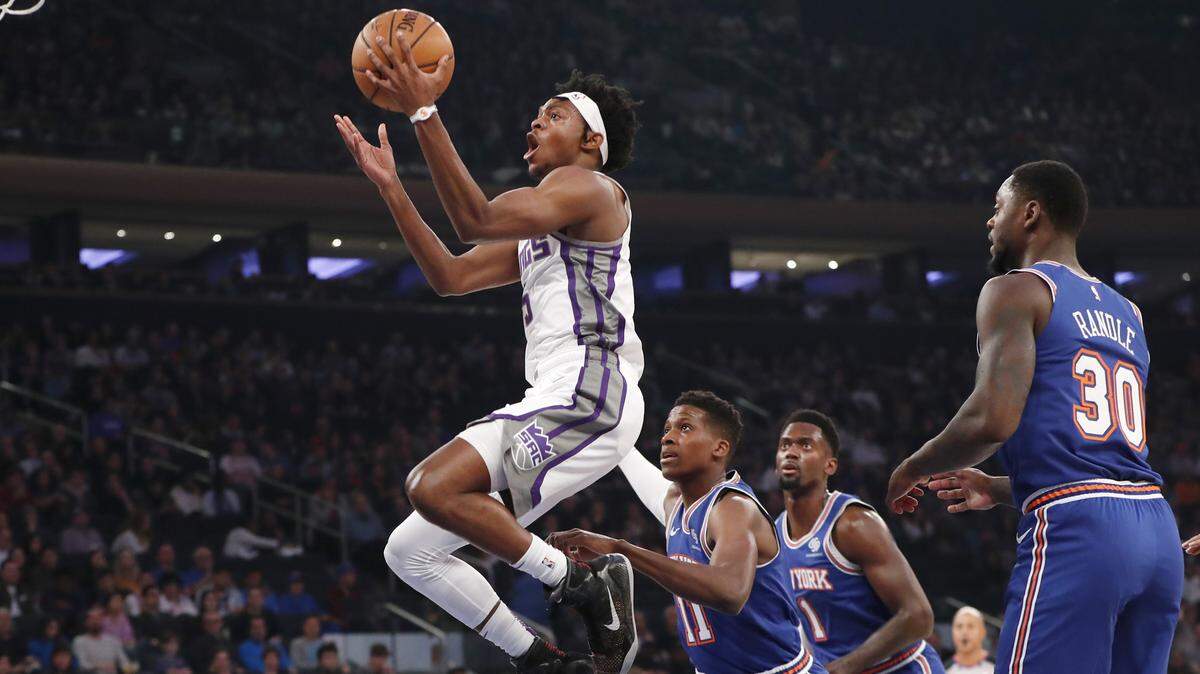 Sacramento’s De’Aaron Fox hits a shot in front of a trio of Knicks during their game in New York on Sunday.