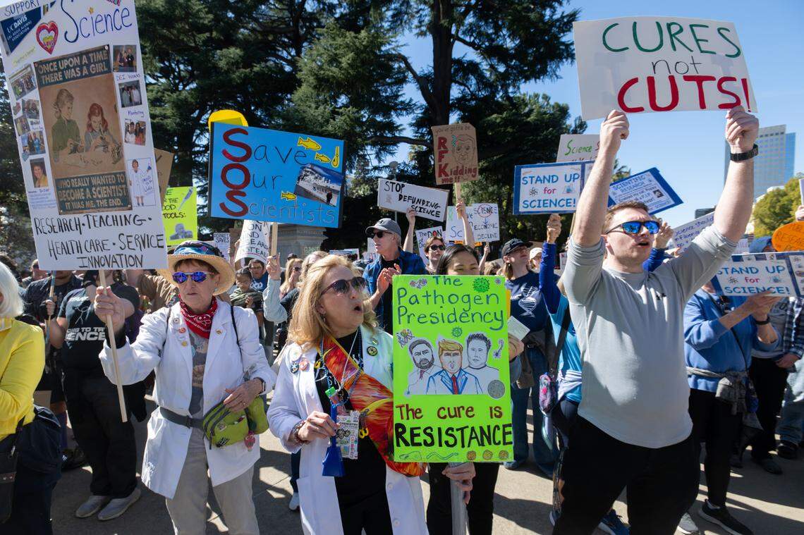 Retired UC Davis professor Judy Kjelstrom, Sacramento resident Crystal Owens and UC Davis grad student Evan Haley hold signs in support of science during a rally at the state Capitol on Friday. The event was part of a nationwide series of protests against Trump administration cuts to science programs. 
