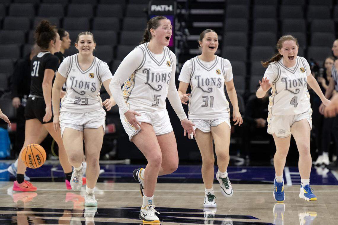 The Faith Christian Lions' Lauren Harris (5) celebrates the victory with Kimber Cunningham (23), Moriah Ely (31) and Ella Haeberle (4) following the 51-37 victory over the Palisades Dolphins in the CIF State Division IV girls basketball championship Saturday at Golden 1 Center.