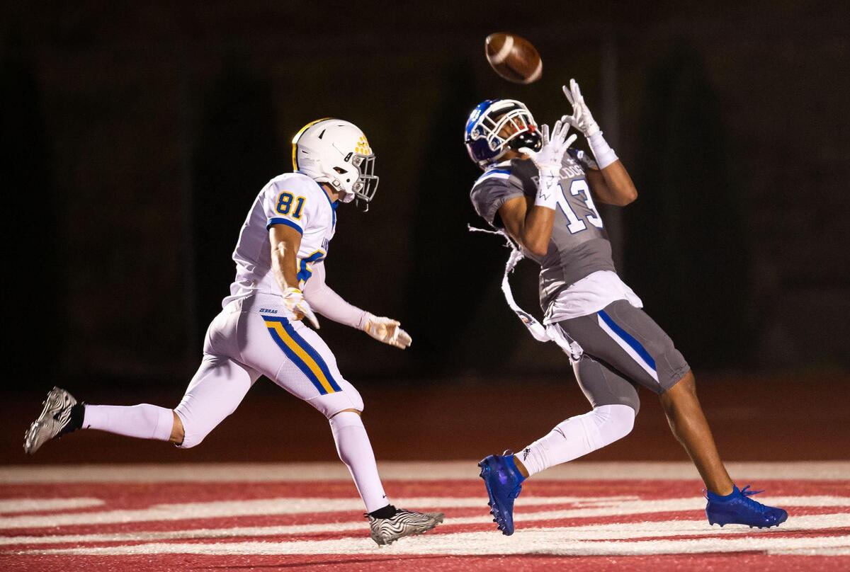 Folsom’s Rico Flores, right, pulls in a Tyler Tremain touchdown pass against Lincoln in April. 