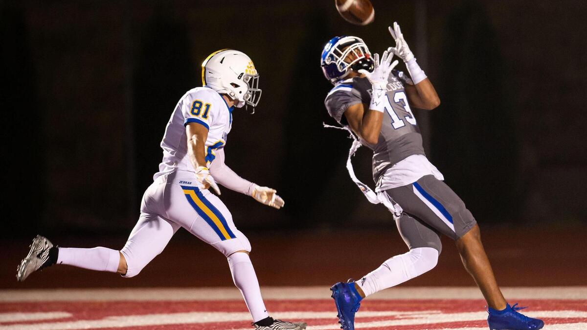 Folsom’s Rico Flores, right, pulls in a Tyler Tremain touchdown pass as Lincoln’s Jacob Flood covers during the second quarter of the high school football game Friday, April 9, 2021, at Folsom High School in Folsom. Folsom beat Lincoln 41-14.