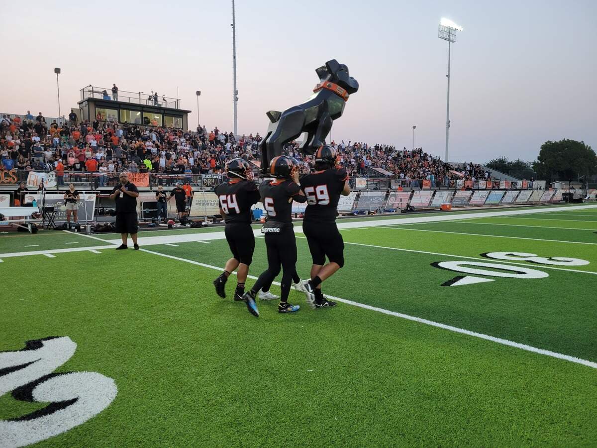 Vacaville High School football players carry the team’s Bulldog mascot onto the field before a game with Oak Ridge on Friday night.