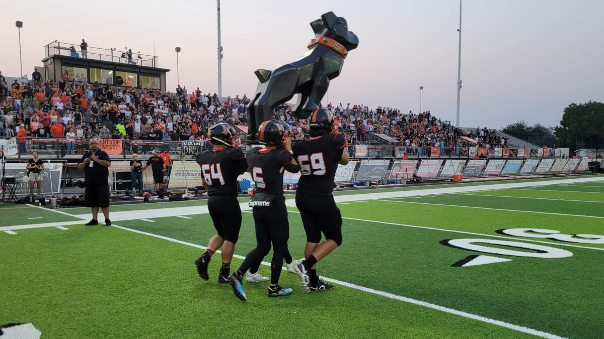 Vacaville High School football players carry the team’s Bulldog mascot onto the field before a game with Oak Ridge on Friday night.