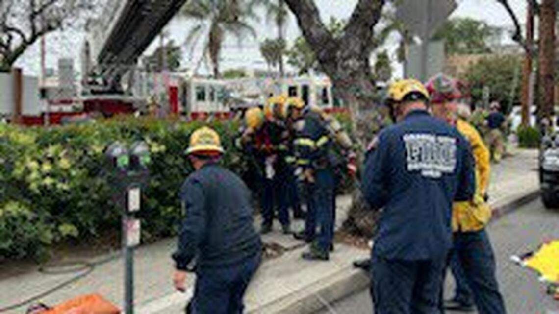 Firefighters rescued a woman found trapped at the bottom of a Santa Ana manhole, California officials say.