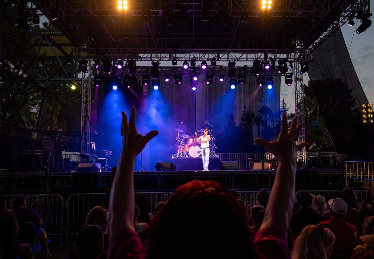 Fans dance, cheer and sing along as Queen Nation, a Queen tribute band, performs on the Golden 1 Stage during the California State Fair at Cal Expo on Tuesday, July 26, 2022, in Sacramento. Gregory Finsley, center, pays homage to Queen frontman Freddie Mercury.