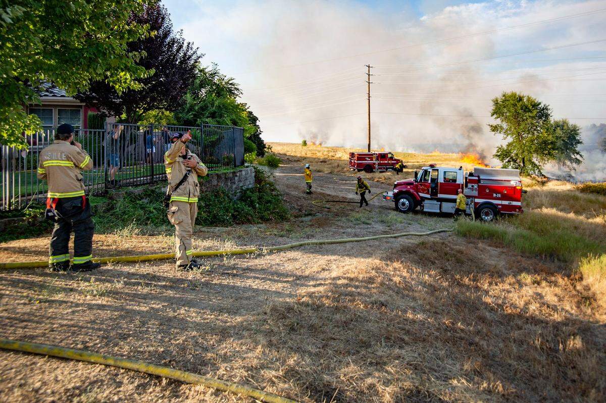 Members of the Roseville and Rocklin fire departments, along with Cal Fire, respond to the Duluth Fire in the fields behind the Blue Oaks neighborhood of Roseville on Monday, Aug. 10, 2020.