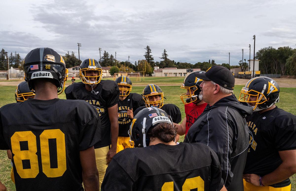 Delta High School football co-head coach Tim Rapp, right, huddles with the offense to give them a play to run during practice on Wednesday, Oct. 20, 2021, in Clarksburg.