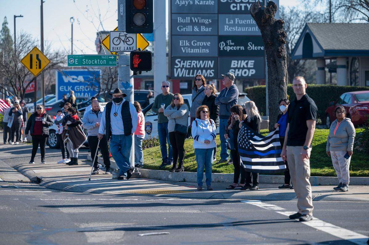 A group of supporters gather on Elk Grove Boulevard as they wait for a procession for fallen Elk Grove police officer Tyler Lenehan on Tuesday, Jan. 25, 2022. Lenehan died after he collided with a wrong way driver on his way to work early Friday morning in Sacramento on Jan. 21.