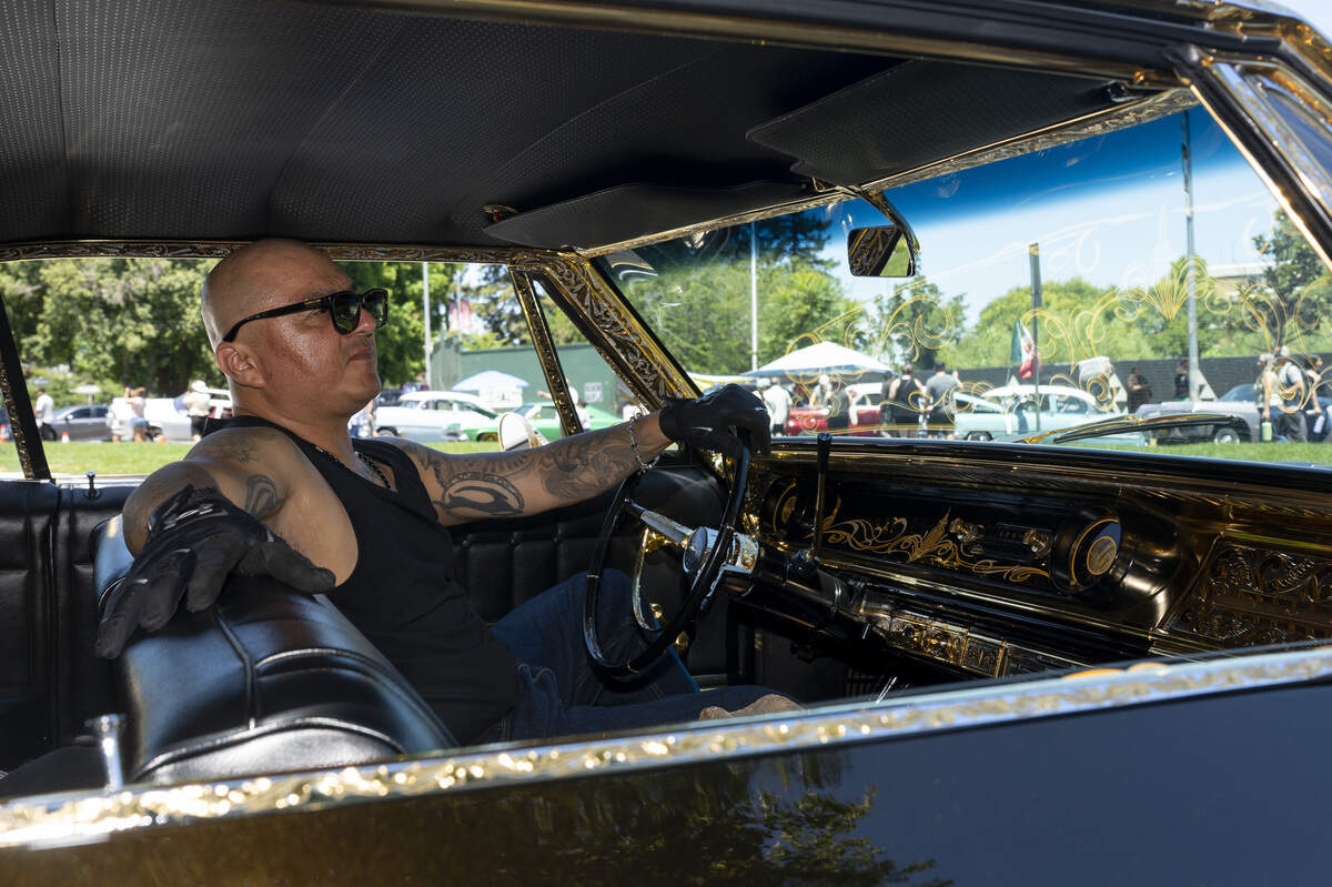 Edgardo Garcia poses for a portrait in his 1965 Chevy Impala during the fourth annual Lowrider Holiday Celebration in Sacramento on Sunday, June 21, 2026. Garcia has owned the car for over 30 years.