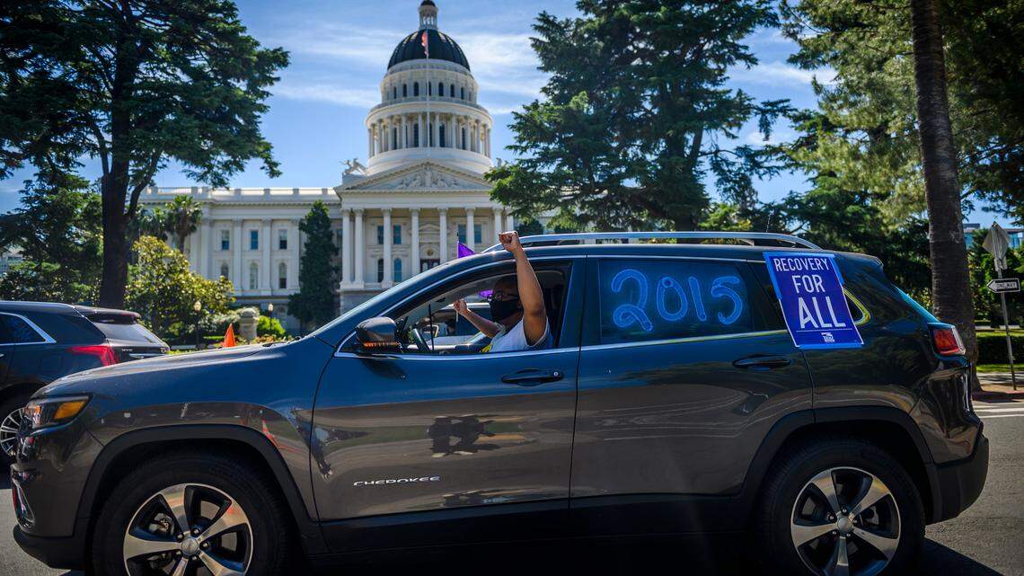 Members of SEIU California Local 2015 honk their horns as their caravan circles the Capitol in downtown Sacramento, Wednesday, May 27, 2020. The car protest called for state leaders to invest in a “recovery for all” as they addresses the coronavirus budget crisis. The group’s demands include rebalancing the economy it says is skewed toward the wealthy and large corporations, avoiding cuts that would impact low-income families, and including immigrant workers and families regardless of immigration status in healthcare and economic safety nets.