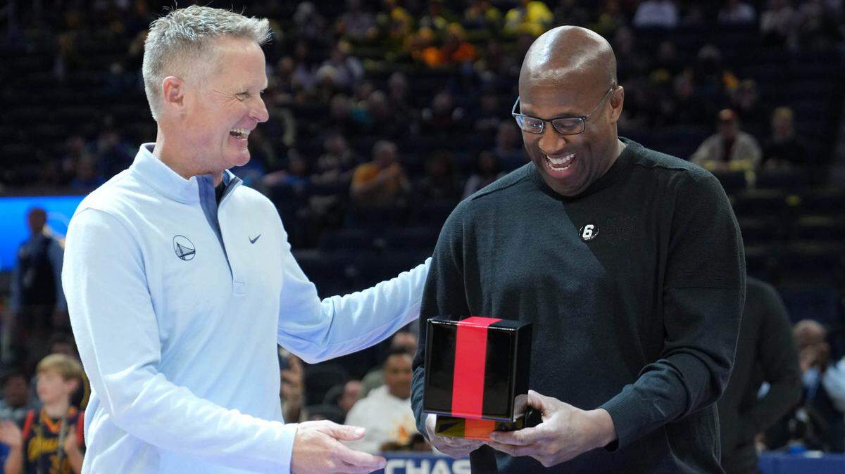 Sacramento Kings head coach Mike Brown, right, receives his championship ring from Golden State Warriors head coach Steve Kerr, left, before the game at Chase Center on Oct. 23, 2022, in San Francisco.