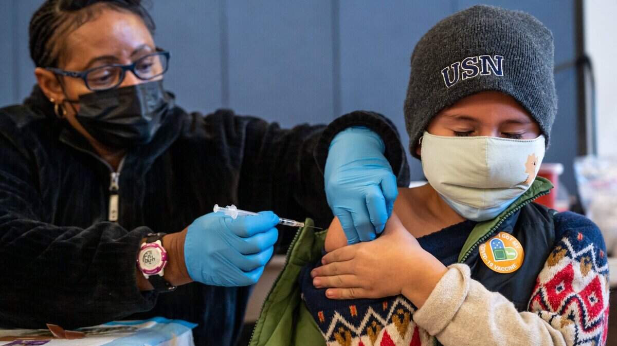Emmanuel Figueroa, de ocho años, en Sacramento, cierra los ojos mientras se prepara para recibir su segunda inyección de la vacuna contra el COVID-19 de manos de Monique Williamson, una enfermera registrada de Elk Grove, durante la clínica de vacunación en el La Familia Maple Neighborhood Center. Una nueva encuesta muestra que la mayoría de los padres de California piensa que es esencial o importante vacunar a sus hijos en edad escolar contra el COVID.