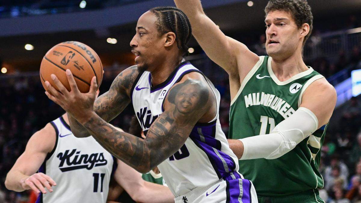 Jan 14, 2025; Milwaukee, Wisconsin, USA;  Sacramento Kings forward DeMar DeRozan (10) looks for a shot against Milwaukee Bucks center Brook Lopez (11) in the first quarter at Fiserv Forum. Mandatory Credit: Benny Sieu-Imagn Images