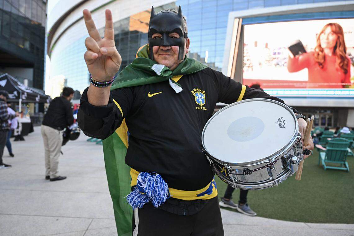 Marcelio Ramos, nativo de Brazil que ahora vive en Berkeley, muestra el signo de la paz mientras espera el World Cup draw con una máscara de Batman en el Chase Center en San Francisco el viernes.
