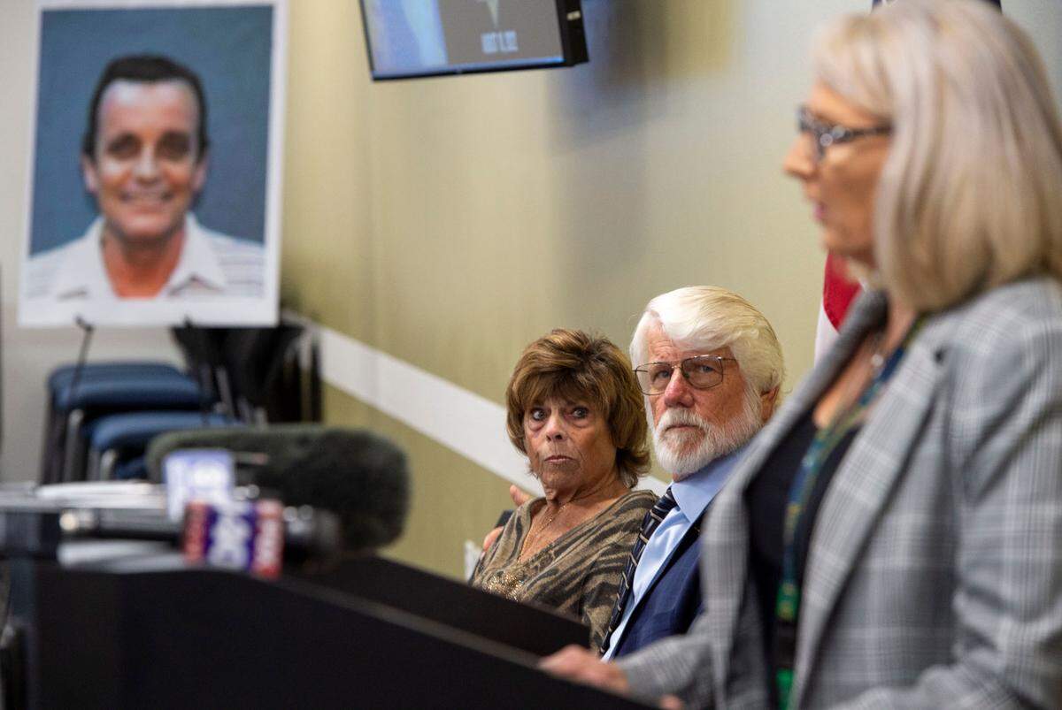 Linda Cox, center, the sister of Nancy Bennallack, sits with her husband Tom Cox as they listen to retired Detective Micky Links during a press conference at the Sacramento County Sheriff’s Office on Wednesday to announce the solving of the 1970 cold case murder. In the background is a photo of Richard John Davis, who was identified as Bennallack’s murder through DNA evidence.