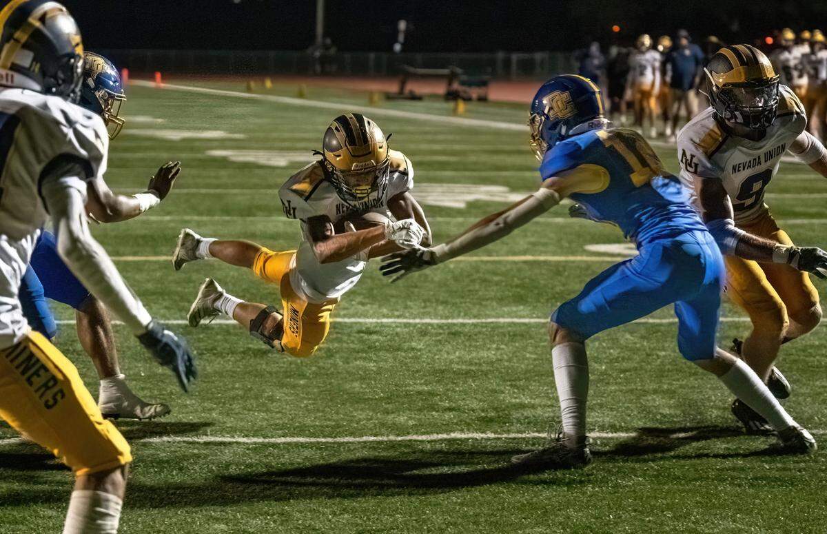 The Nevada Union Miners’ Nate Pritchett (4) dives into the end zone for touchdown against the Del Campo Cougars in the first quarter on Friday.