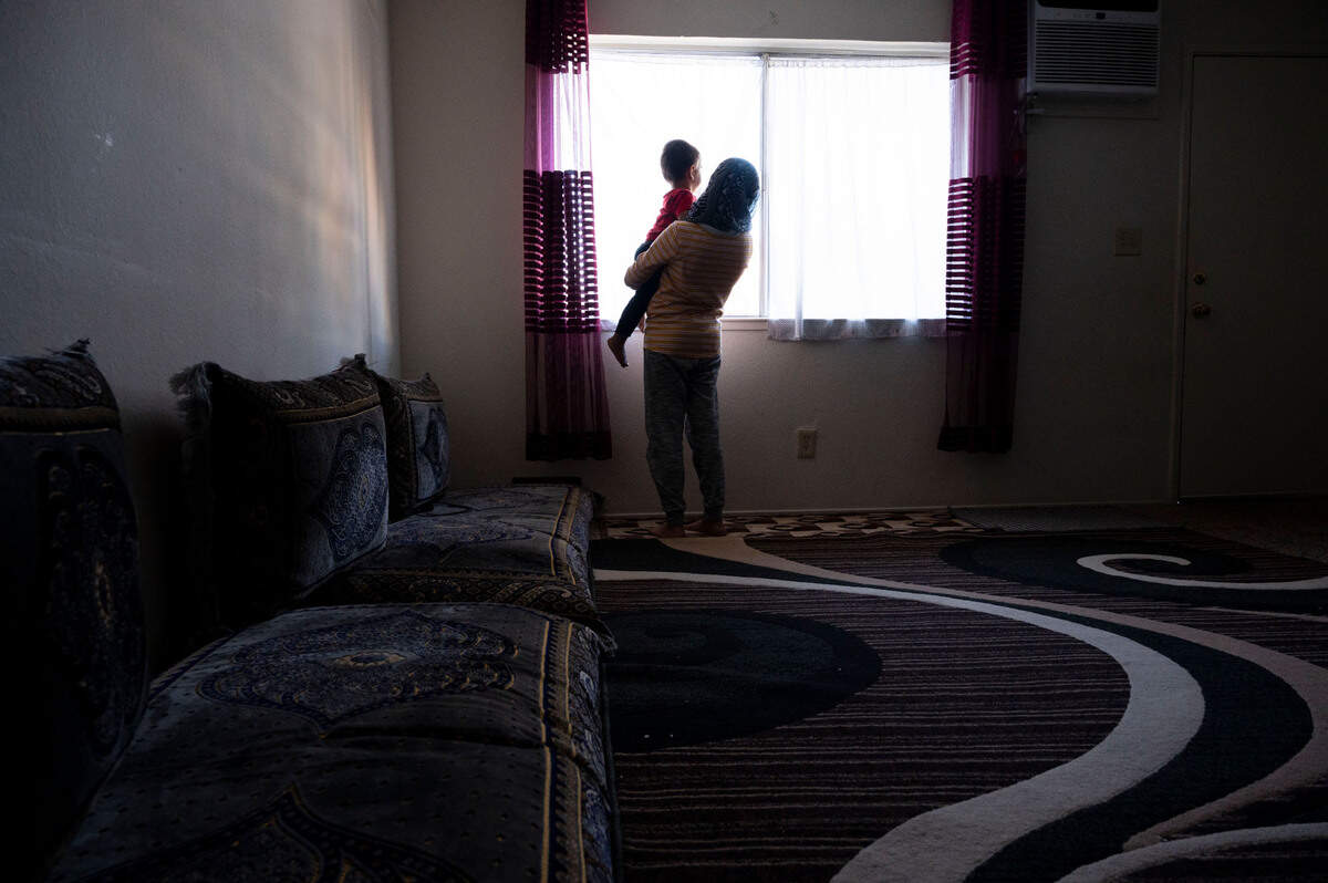 Two Afghan refugee children look out the window of a sparsely furnished one-bedroom apartment in West Sacramento where they live with their mother and two siblings on Nov. 24. They are one of the families being helped by the Yolo County Children’s Alliance.