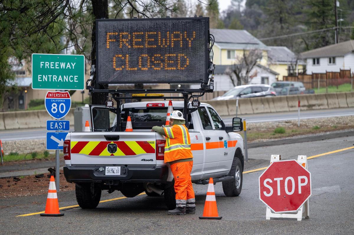 A Caltrans worker stands on a closed onramp to Interstate 80 in Colfax on Saturday, March 2, 2024. The interstate was closed from Colfax to the state line due to vehicles becoming stranded in blizzard conditions overnight.