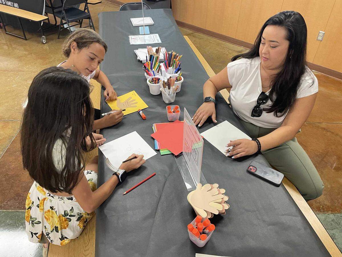 Two Elk Grove Unified students and an employee decorate their community quilt squares at the Smithsonian’s “The Bias Inside Us” exhibit on June 15, 2024, at Elizabeth Pinkerton Middle School.