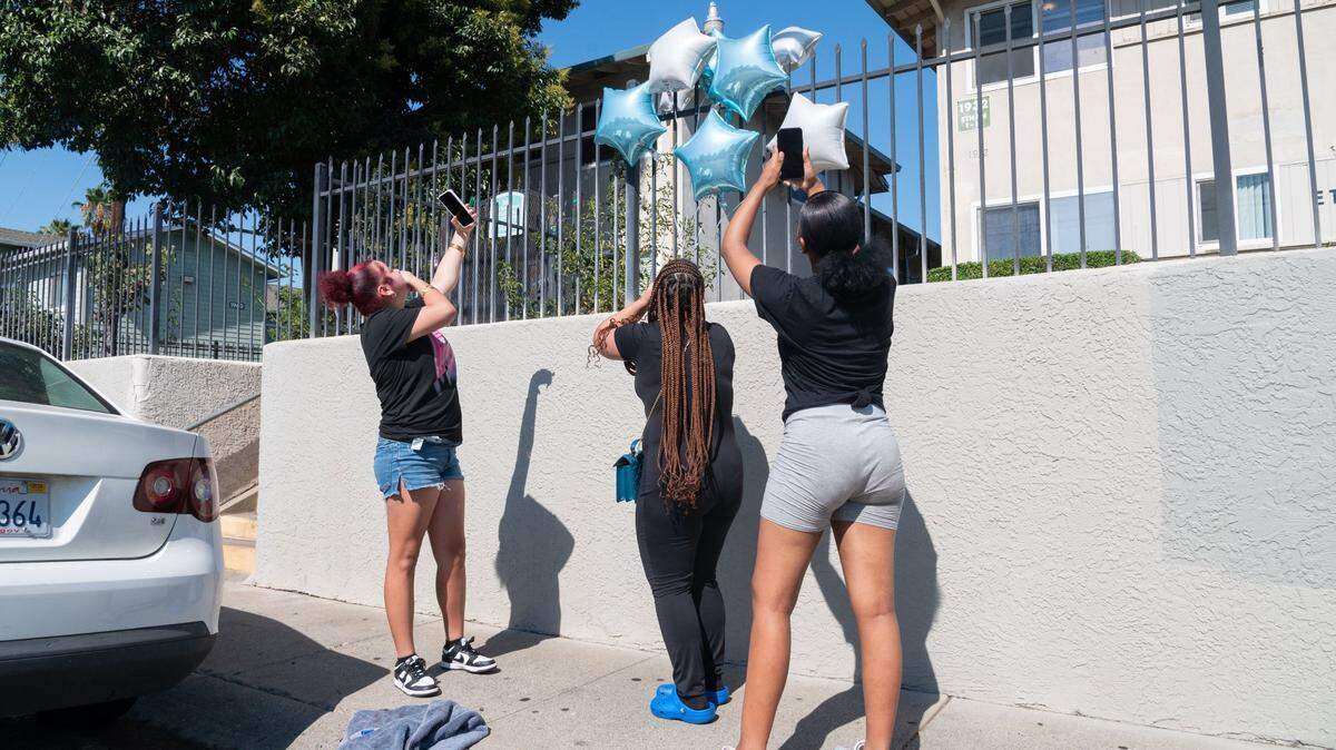 Myiah Wooders, 15, left, Sade Rodriguez, 16, center, and Leah Whitmore, 14, right, release three white balloons into the air in front of the Ethan Apartments in Arden Arcade on Tuesday in honor of their 15-year-old friend who was fatally shot the night before. Sgt. Amar Gandhi, a spokesman with the Sacramento County Sheriff’s Office, said the 15-year-old boy was pronounced dead after being taken to a hospital.
