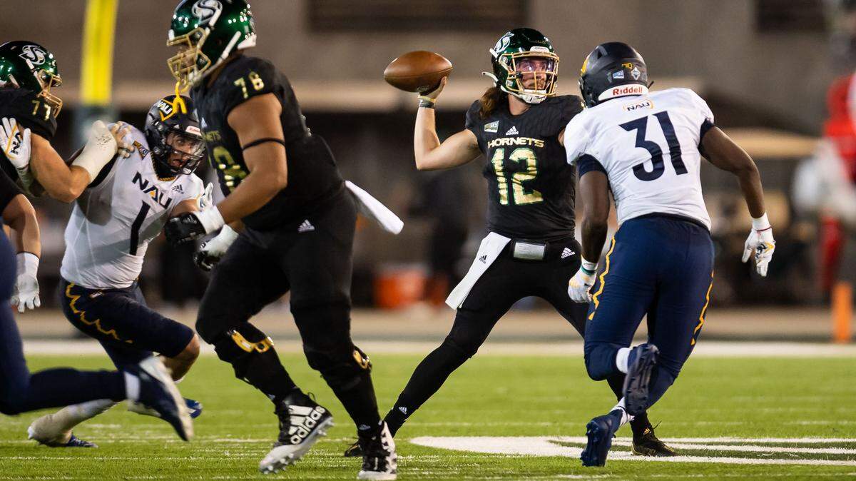 Sacramento State Hornets quarterback Jake Dunniway (12) pass the ball before Northern Arizona Lumberjacks linebacker Jhasi Wilson (31) can reach him during the first half of the Hornets’ homecoming NCAA football game Saturday, Oct. 23, 2021, at Hornet Stadium in Sacramento.