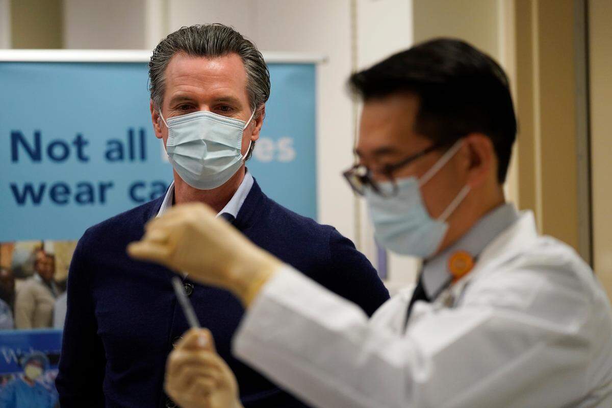 California Gov. Gavin Newsom watches as the Pfizer-BioNTech COVID-19 vaccine is prepared by Director of Inpatient Pharmacy David Cheng at Kaiser Permanente Los Angeles Medical Center in Los Angeles on Monday, Dec. 14, 2020.