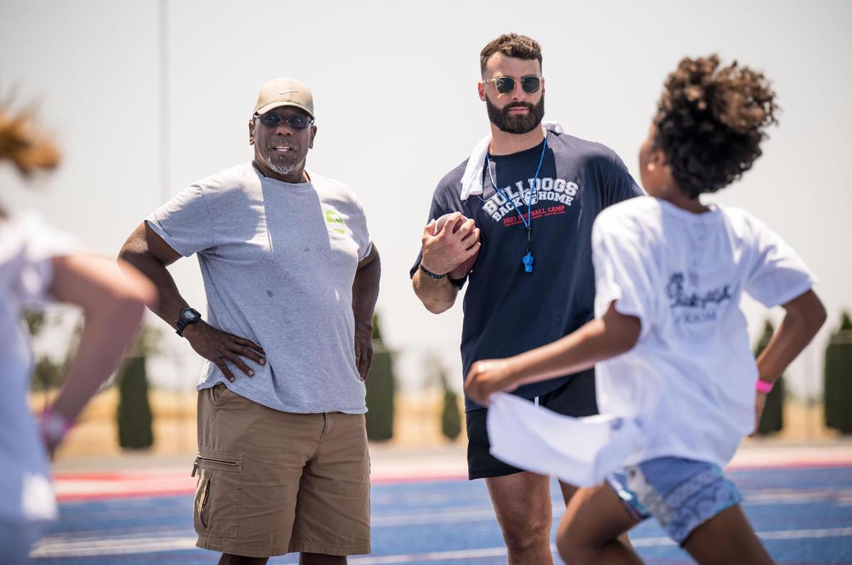 Former Folsom High School football head coach Terry Richards, left, catches up with Green Bay Packers tight end and former Bulldog Josiah Deguara during the Bulldogs Back Home 2023 football camp on Saturday, June 17, 2023, at Folsom High School. Along with Deguara, current NFL players and past Bulldogs Jack Browning and Jonah Williams — along with Richards’ son and former player Jordan Richards — worked alongside head coach Paul Doherty and other Folsom coaches to run the youths through drills.