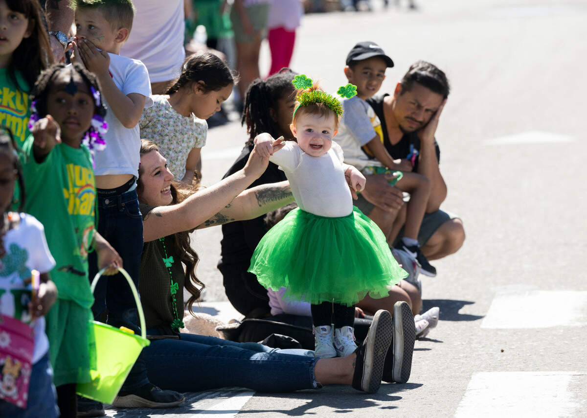 Juniper Vengelen, 1, is held by her mom Tiffany as she and other families watch the annual St. Patrick’s Day parade in Old Sacramento on Saturday, March 16, 2024.