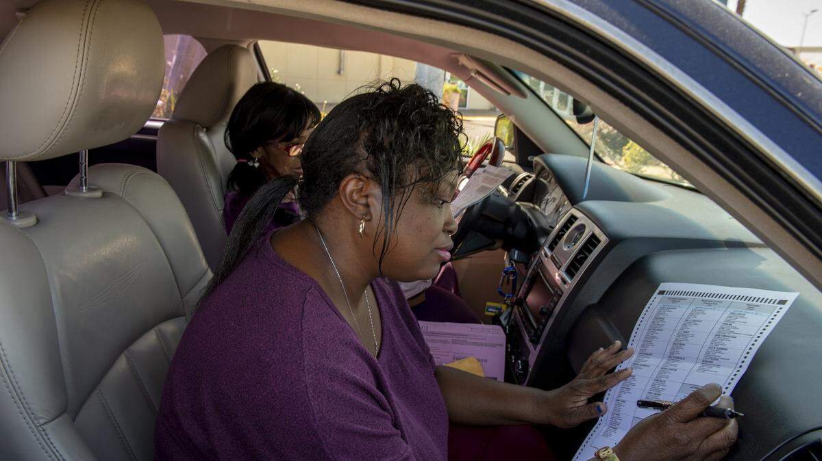 Keisha Williams and her mother Maryann Williams fill out their ballots in their car outside the Sacramento County elections office on 65th Street on June 5. Voting is well underway for the Nov. 6 election.
