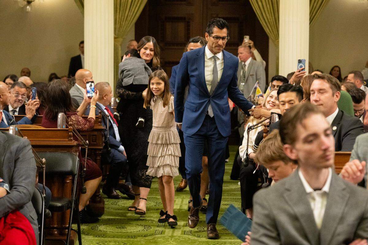 Assembly Speaker Robert Rivas, D-Hollister, walks to the dais with his daughter, Melina, 9, after being sworn in at the state Capitol on Monday during the Assembly’s first meeting of the new legislative session.