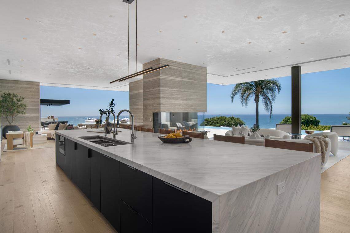The architecturally stunning estate spans 7,356 square feet with 5 bedrooms and 7 bathrooms and offers breathtaking panoramic ocean views from its perch above Malibu Cove Colony.
