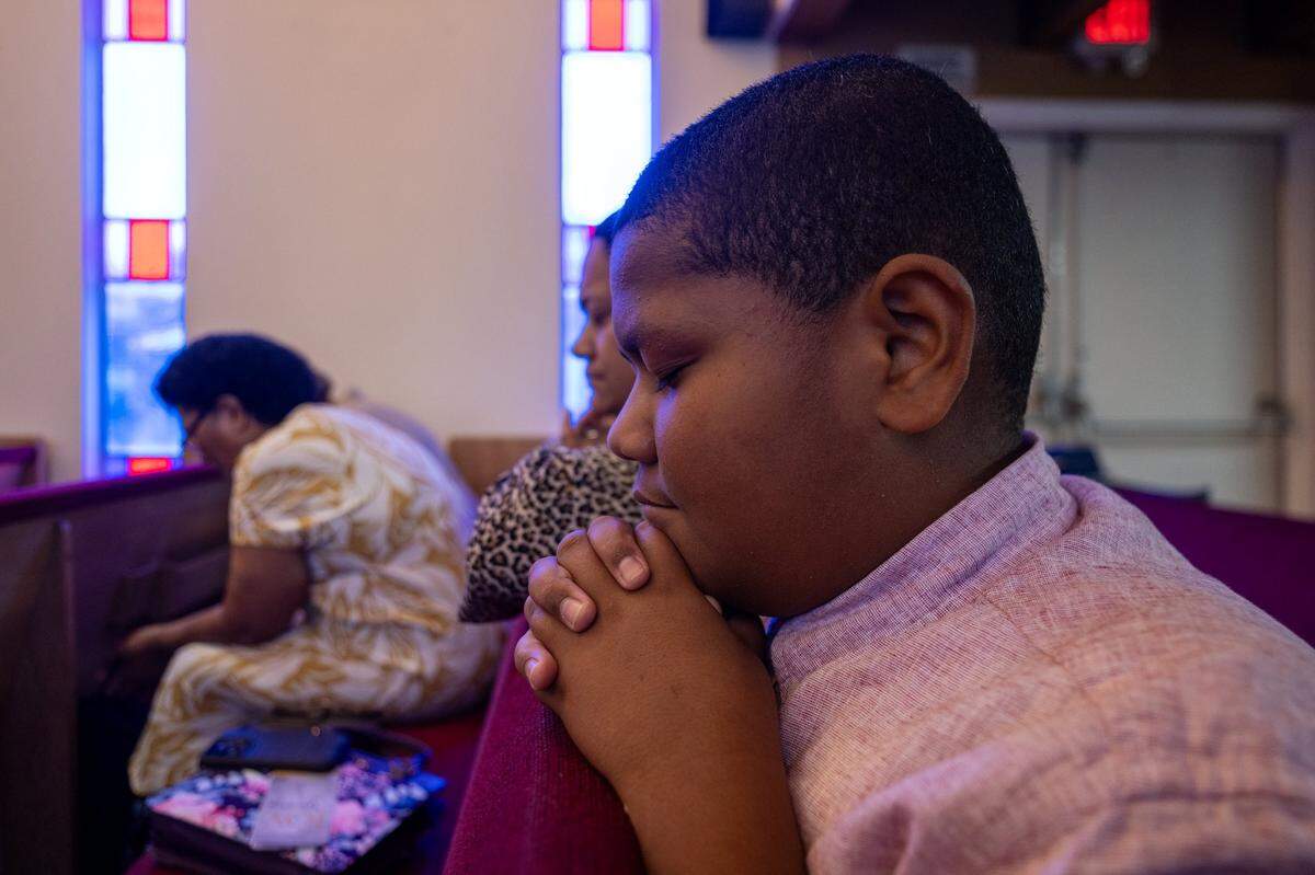 Justin Soaani, 10, prays during at a Sacramento Fijian Seventh-Day Adventist Church service earlier this month in Carmichael.
