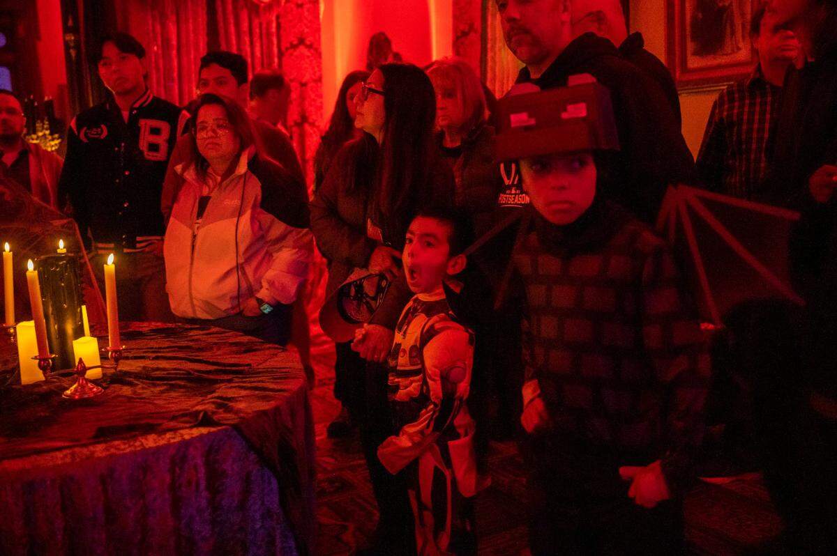 Alexander Casciato, 5, center, sees a jaw dropping scene in the seance room while touring the Halloween-decorated Leland Stanford Mansion State Historic Park on Friday, Oct. 27, 2023, along with his brother, Dominic, 8, right, and his parents, Michelle and Al Casciato. Tours will continue from now through Halloween.