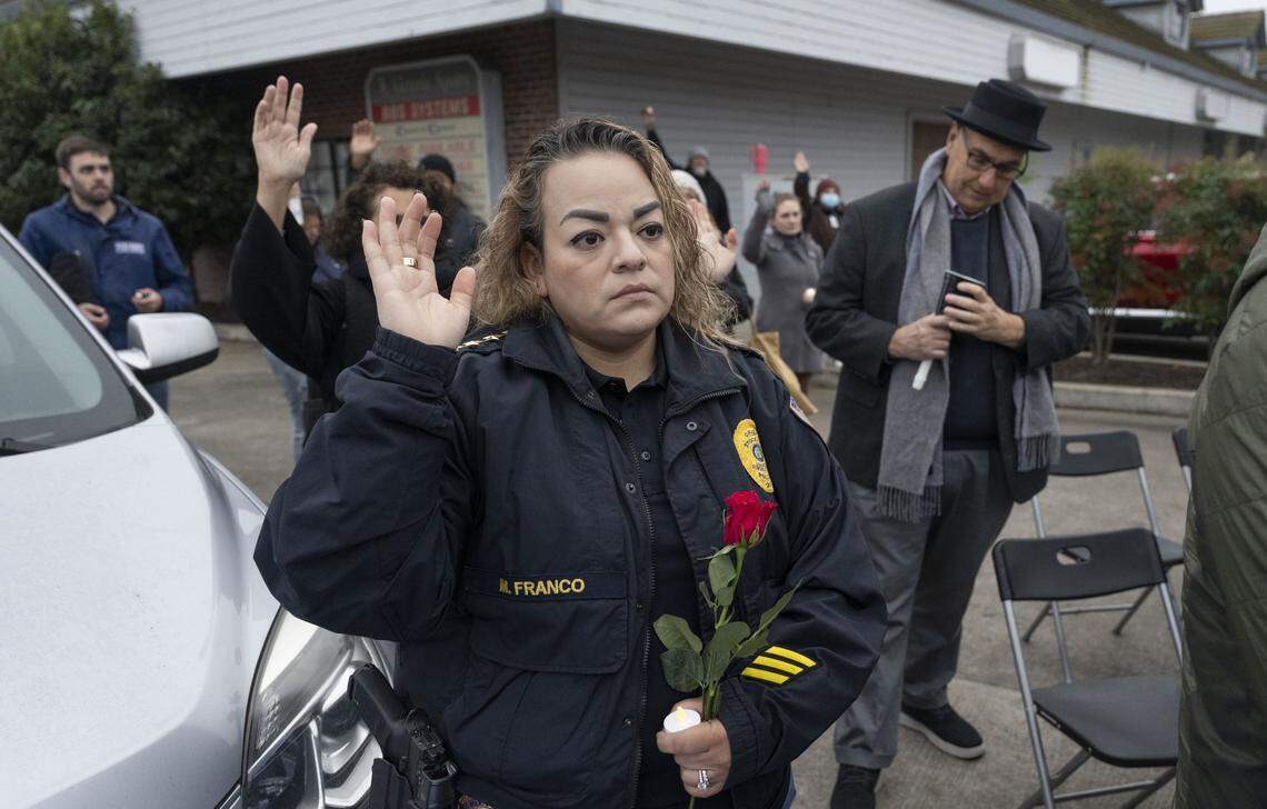 Mayra Franco, police chief of the Stockton Unified School District, raises her hand as community members respond to a speaker at a vigil on Sunday, Nov. 30, 2025, for the four people killed and 11 injured after a mass shooting near Stockton the night before.