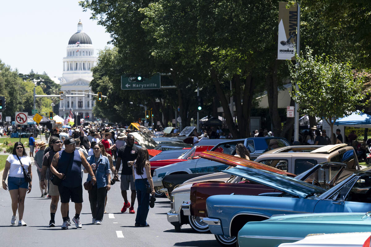 Lowriders and car enthusiasts admire cars parked along Capitol Mall during the fourth annual Lowrider Holiday Celebration in Sacramento on Sunday, June 21, 2026.