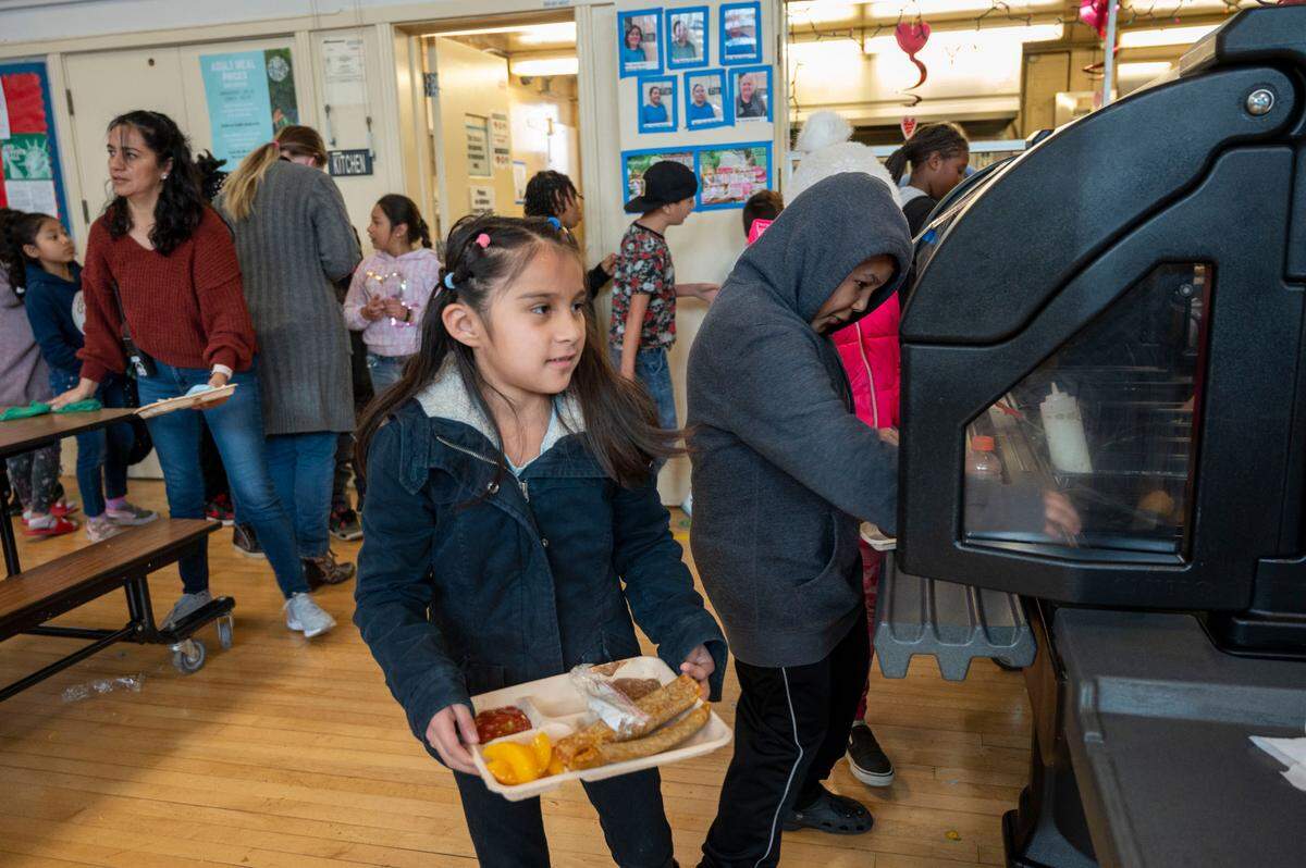 Sophie Espinoza, de ocho años, busca un asiento después de recibir su almuerzo escolar en la cafetería de Oak Ridge Elementary, la semana pasada. Sacramento City Unified sirve unos 8,300 desayunos y 23,000 almuerzos al día, según funcionarios del distrito.