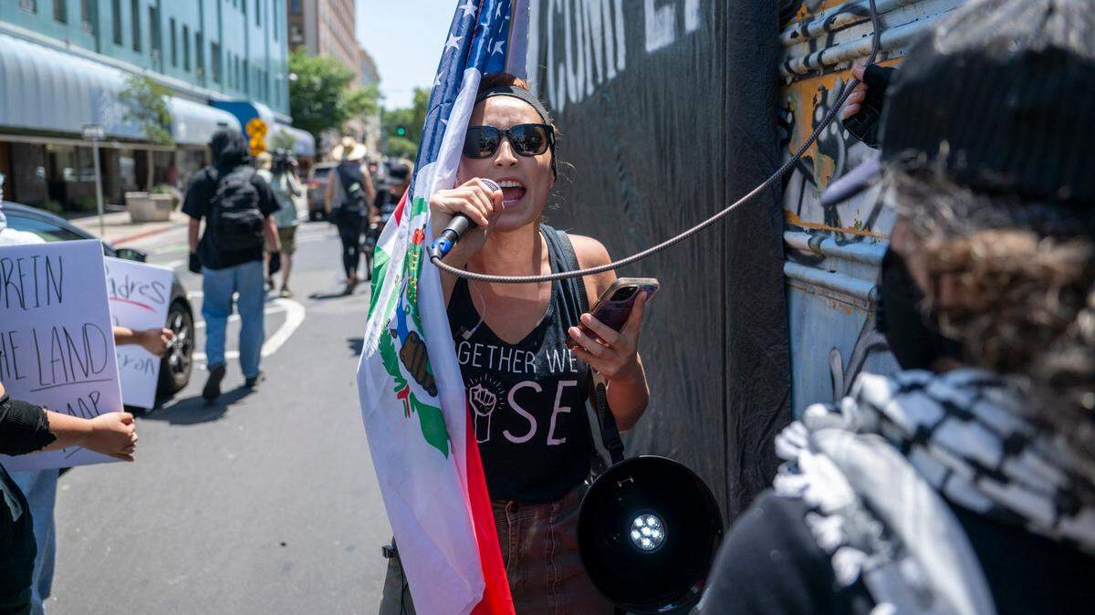 Tatiana Lopez leads demonstrators in chants as they march to the U.S. Immigration and Customs Enforcement office in downtown Sacramento on Monday.