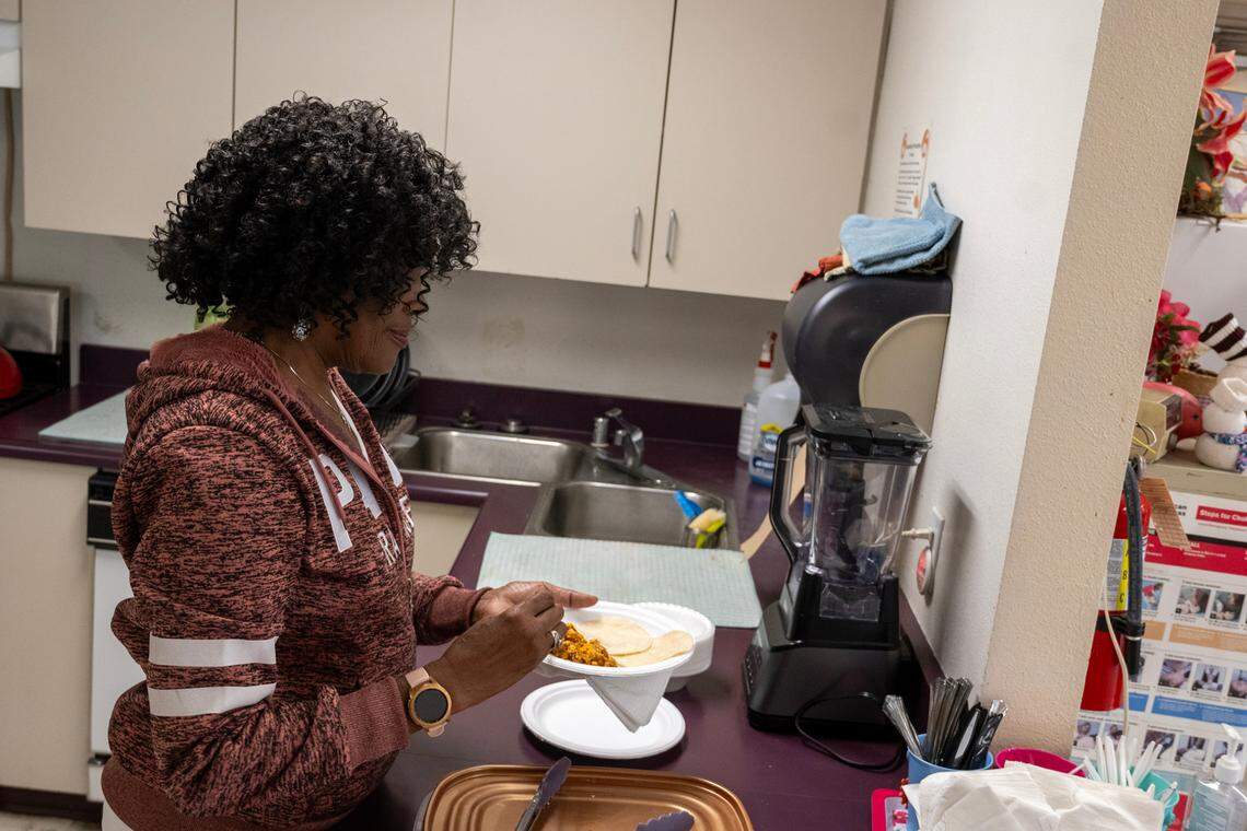 Diane Washington, activities assistant, serves up lunch at the Stanford Settlement Neighborhood Senior Center on Nov. 17, where their kitchen sink needs replacing.