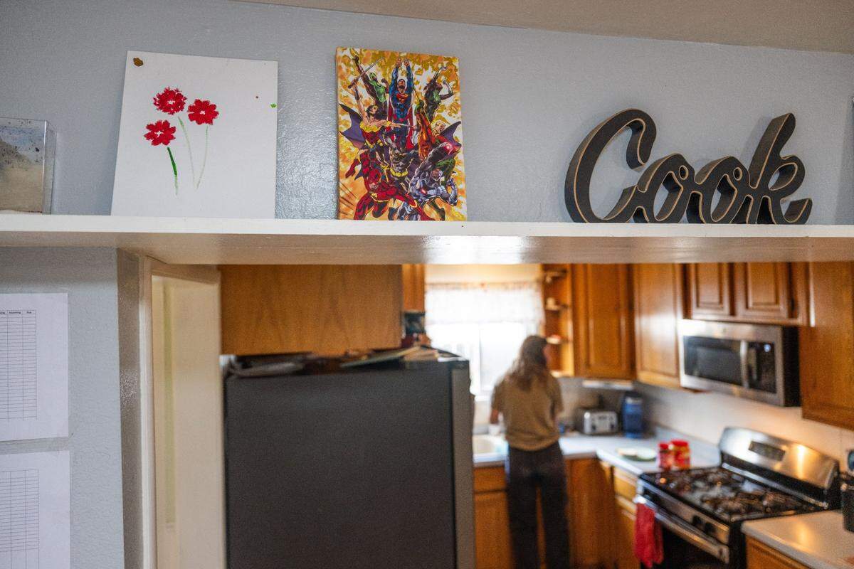 An employee prepares a sandwich in April at Progress Ranch, a Davis short-term residential therapeutic facility for boys ages 6-13 who need full-time care. Artwork that the children have made in the past hangs on a shelf.