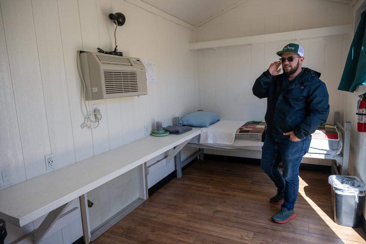 Alexander Garlinger, program director for The Grove, talks about the importance of maintaining the facility’s 50 tiny cabins for homeless transitional-age youth while giving a media tour on Wednesday.