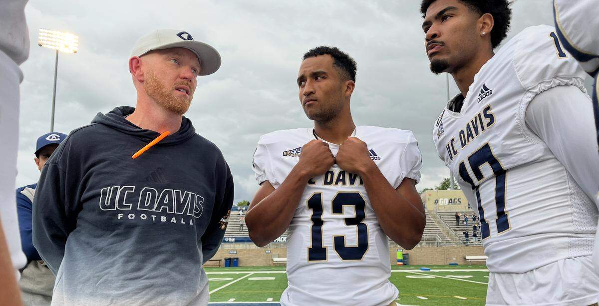 UC Davis football offensive coordinator Paul Shelton, left, talks with quarterbacks Caden Pinnick (13) and Damon Wrighster (17) after the spring game Saturday.