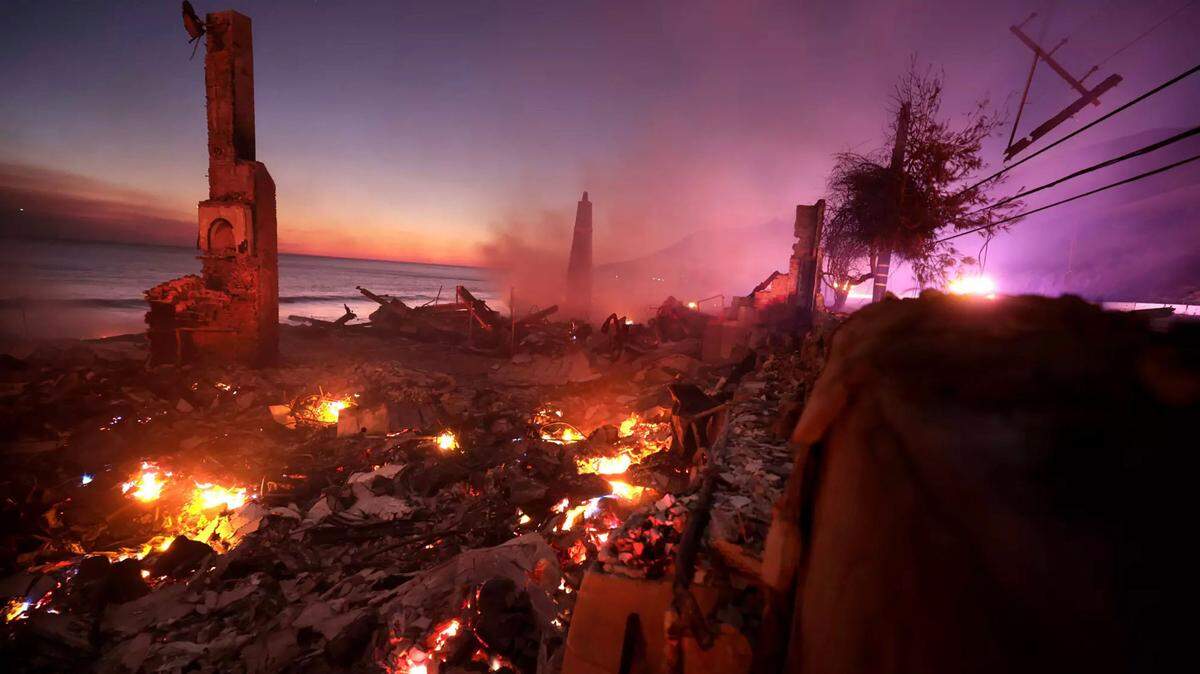 A house burns along the Pacific Coast Highway as the Palisades Fire burns in Malibu last week.