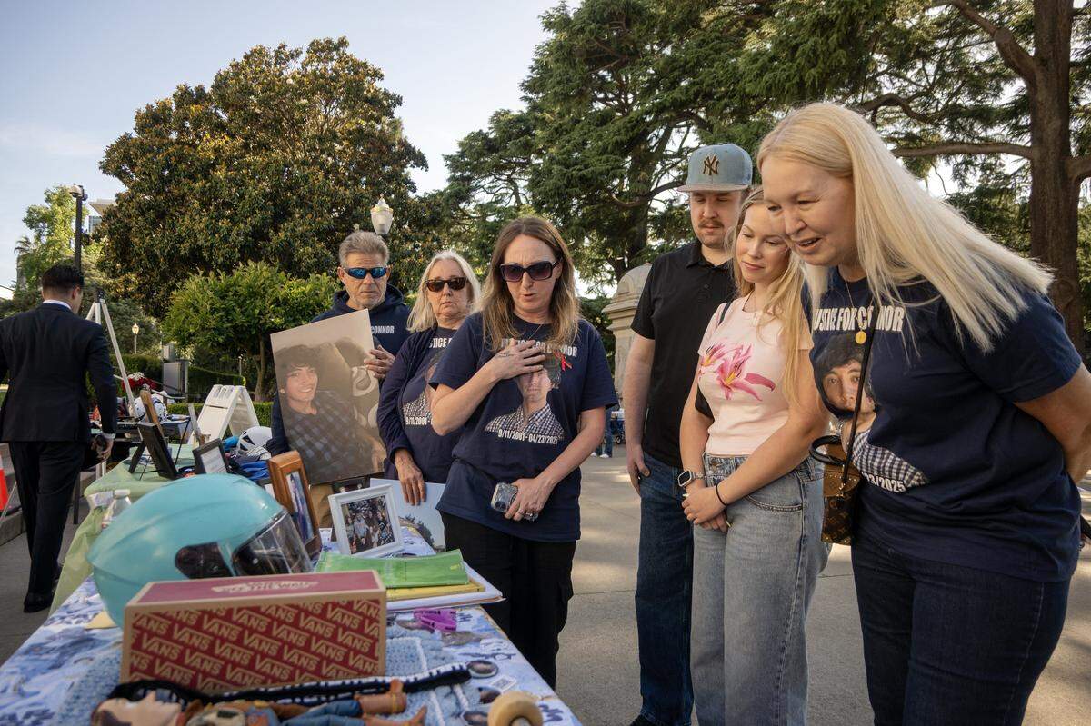 Allison Lyman, center, mother of Conner Lopez, displays some of Conner’s belongings at the memorial rally for victims of vehicular violence at the California State Capitol on Thursday.