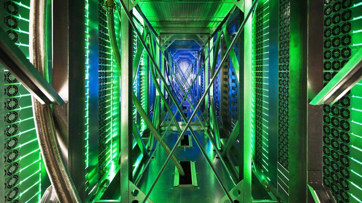 In this undated photo made available by Google, hundreds of fans funnel hot air from the computer servers into a cooling unit to be recirculated at a Google data center in Mayes County. Okla. The green lights are the server status LEDs reflecting from the front of the servers. (AP Photo/Google, Connie Zhou)