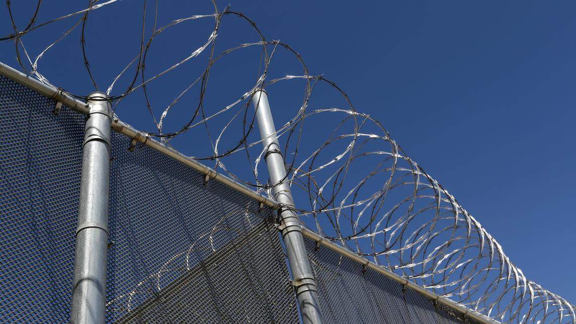 In this Wednesday, Aug. 28, 2019, photo shows chain-link fence and razor wire surrounding the exercise fields at the Adelanto ICE Processing Center in Adelanto, Calif. The facility is a privately operated immigration detention center run by the GEO Group, which can house up to about 1900 total immigrant detainees, both male and female.(AP Photo/Chris Carlson)